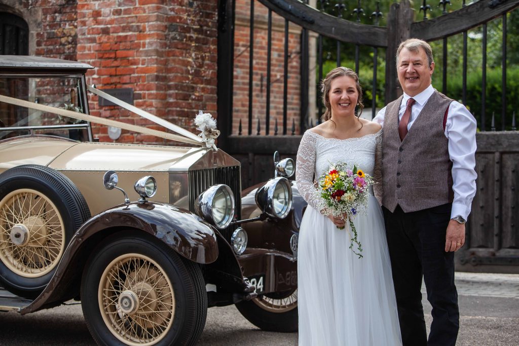 bride and father with vintage wedding car