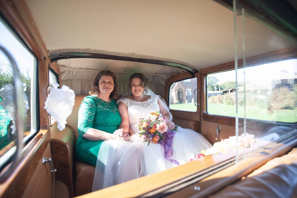 bride with mum in vintage wedding car
