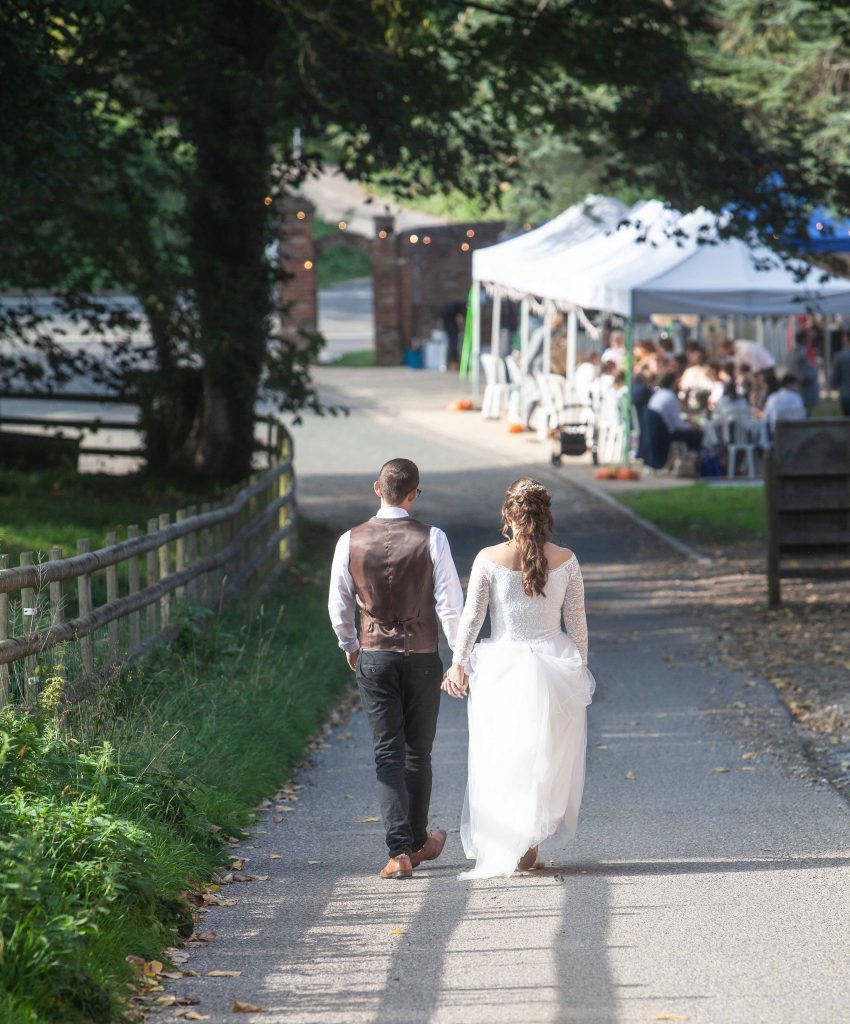 bride and groom walking towards marquee