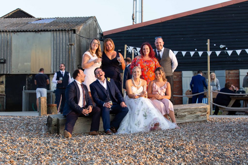 wedding guests with bride and groom on beach