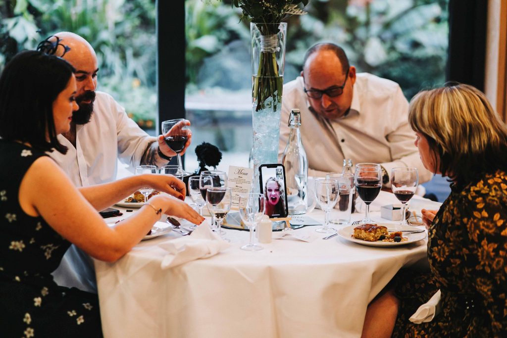 wedding guests and zoom call by phone at wedding
