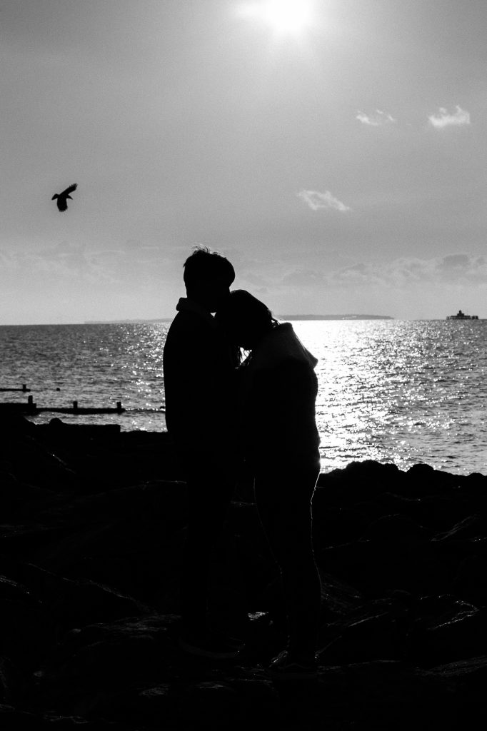 picture of couple silhouetted on beach in black and white