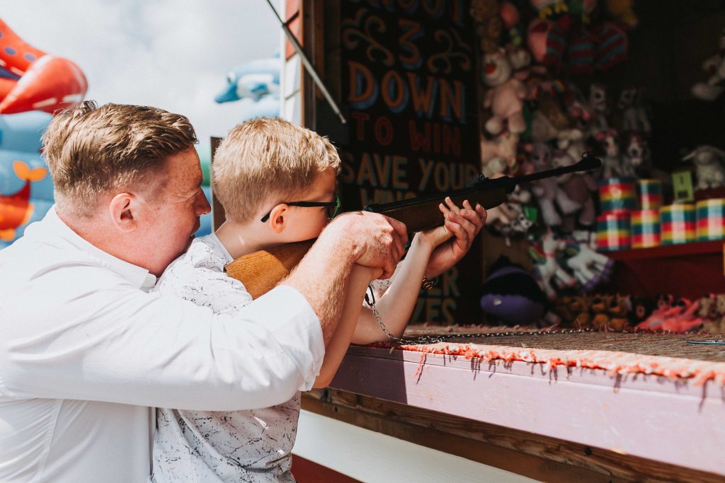dad helping son at arcade shooting gallery on herne bay pier