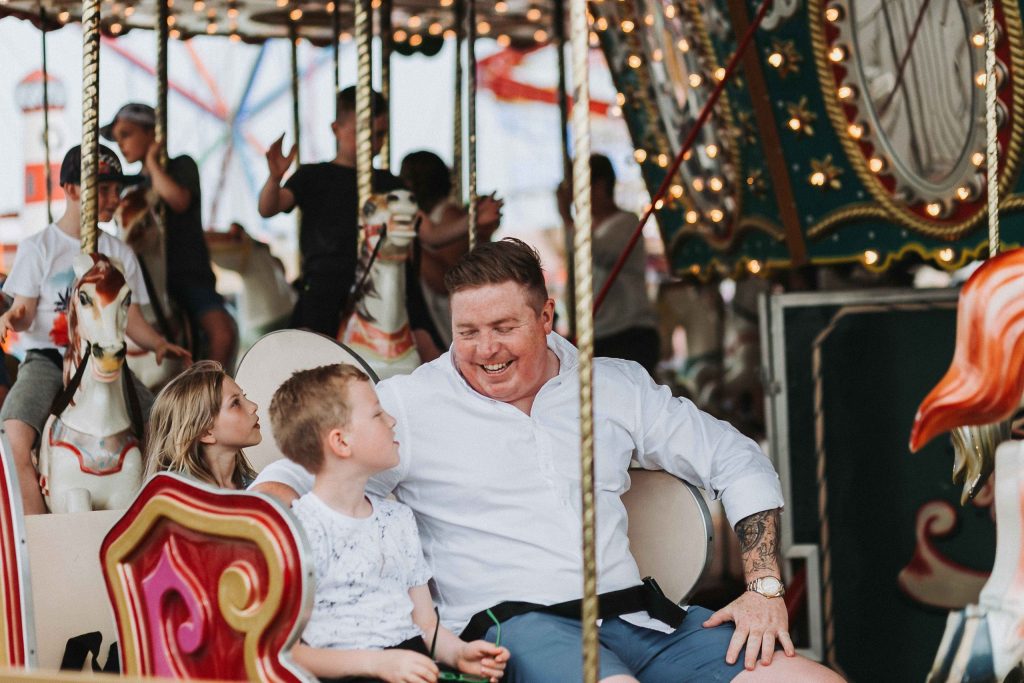 dad and son on carousel together smiling