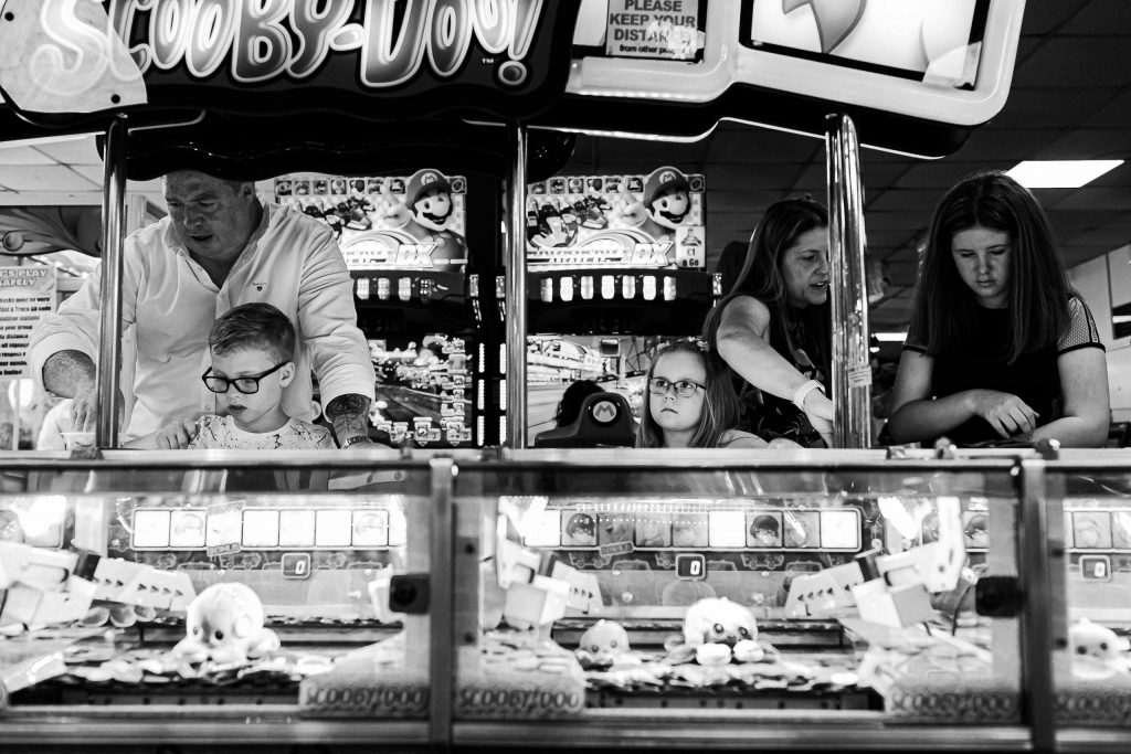 family playing together on penny arcades in amusements