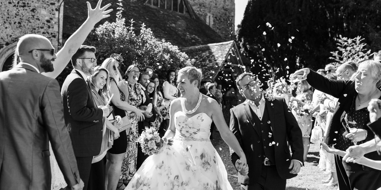 Bride and groom having confetti thrown at them outside of church in Preston, Kent