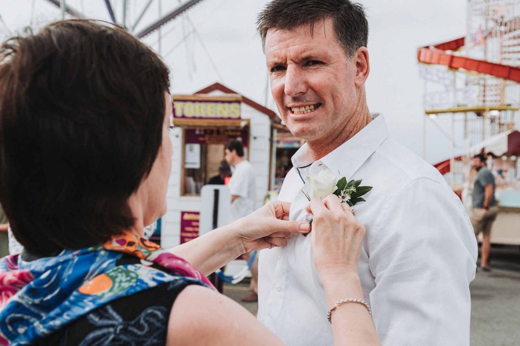 Groom having flower button adjusted