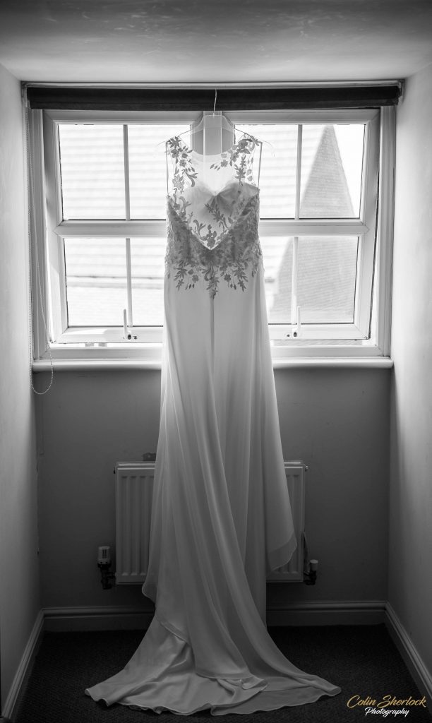 wedding dress hanging in window