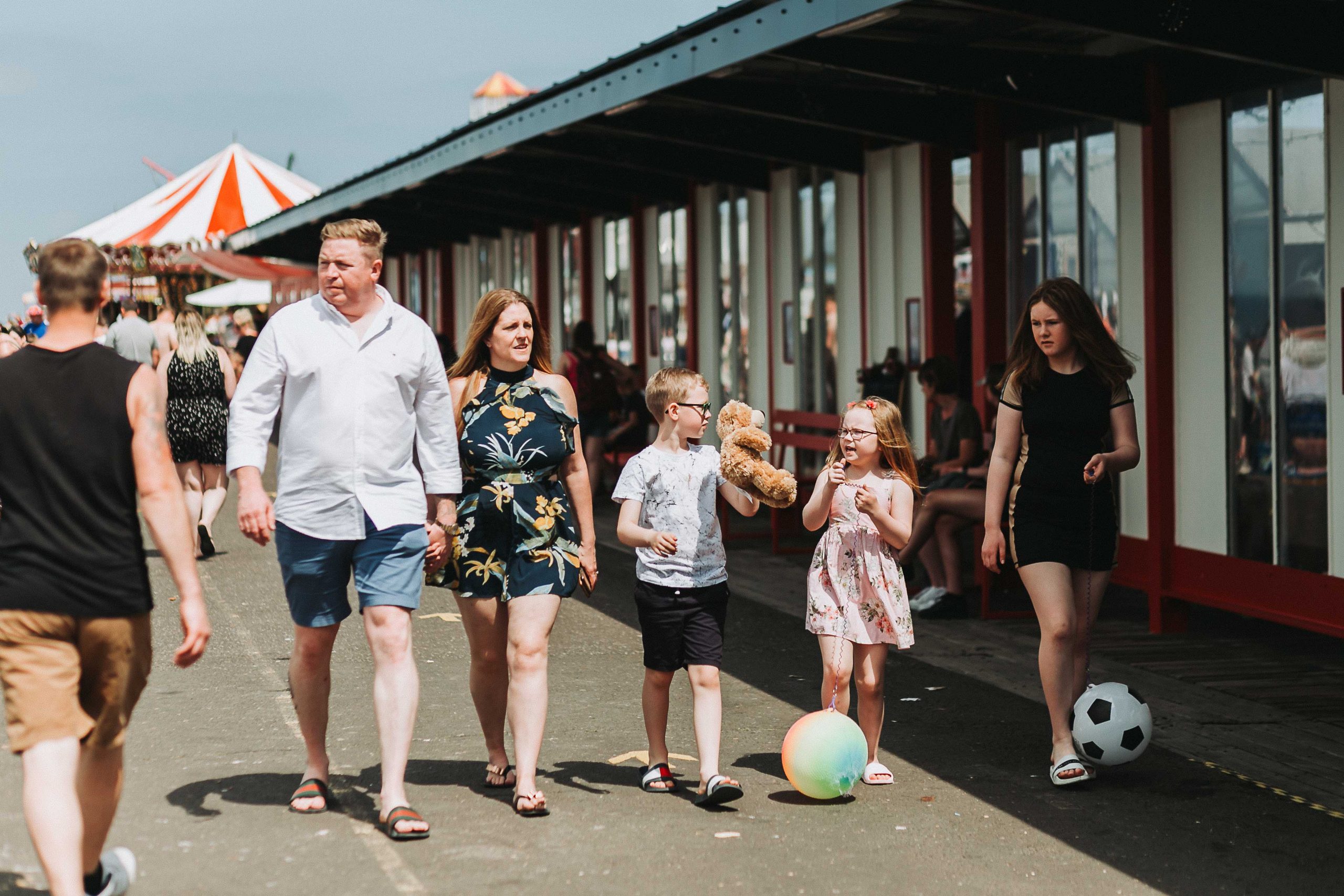 family walking on herne bay pier in the sunshine.