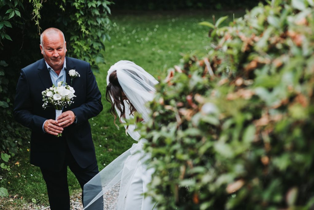 father of bride holding flowers