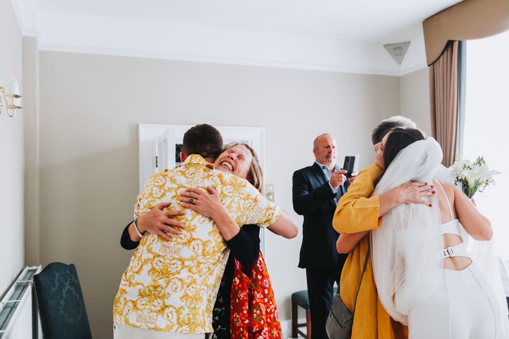 mums hugging bride and groom