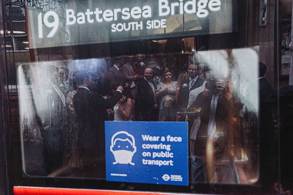 reflection of bride and groom and guests in bus window