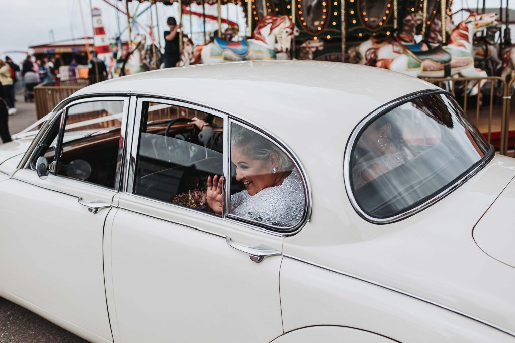 bride waving from wedding car on herne bay pier