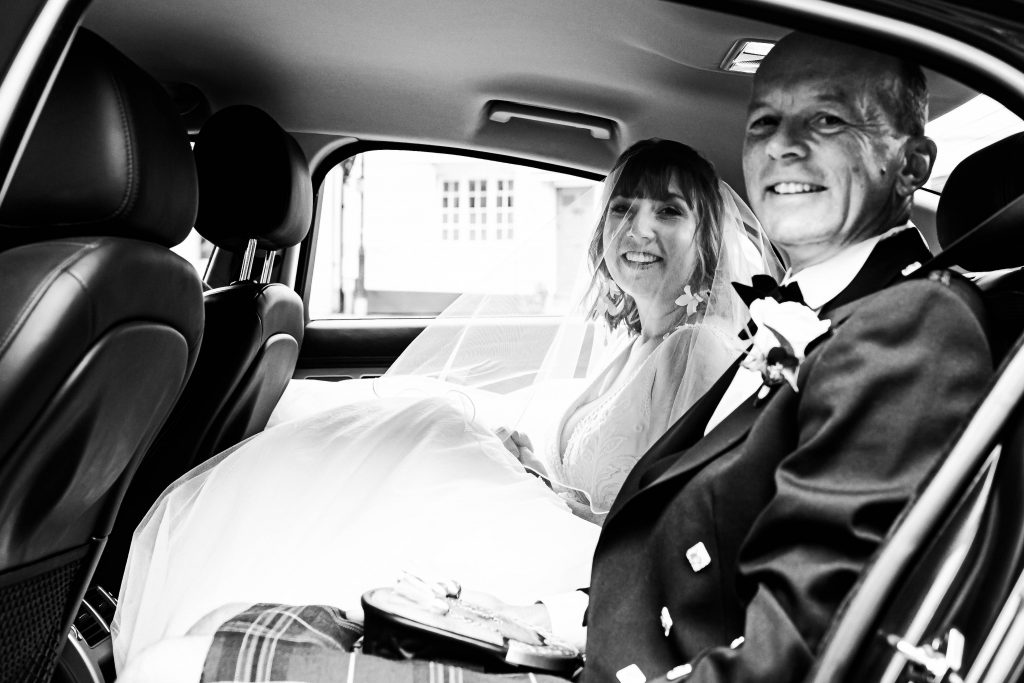 bride with dad in wedding car