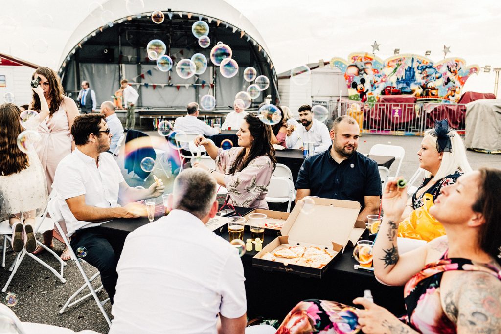bubbles being blown by guest at beach hut wedding venue