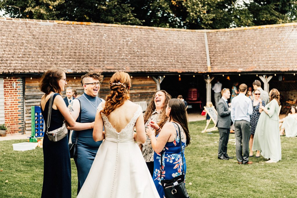 wedding guests laughing outdoors at afternoon reception at The Night Yard wedding venue