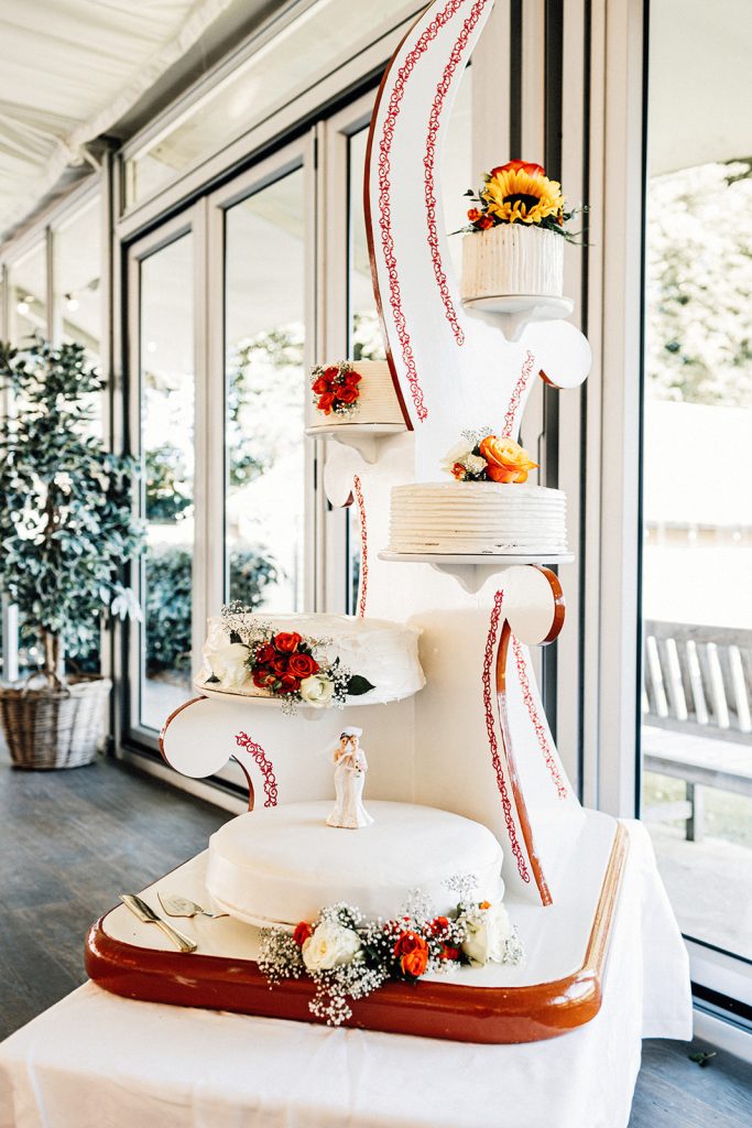 wedding cake displayed on a stand with 5 tiers.