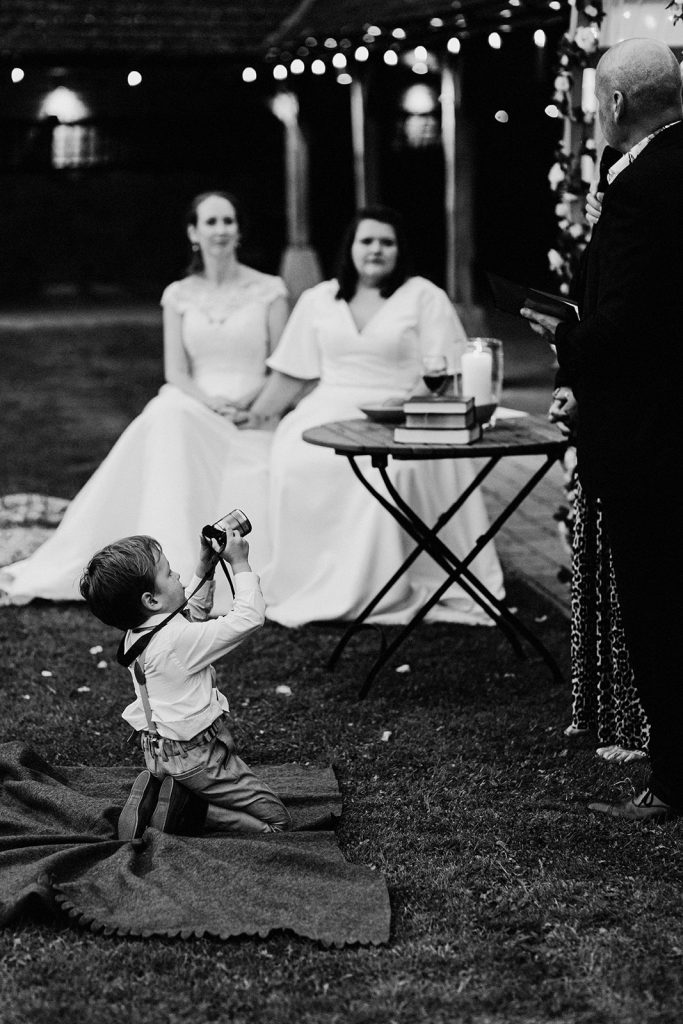 small boy with camera taking pictures of wedding ceremony