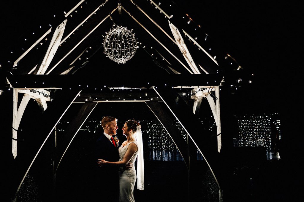 bride and groom portrait at night with flash under Winters Barns arch.
