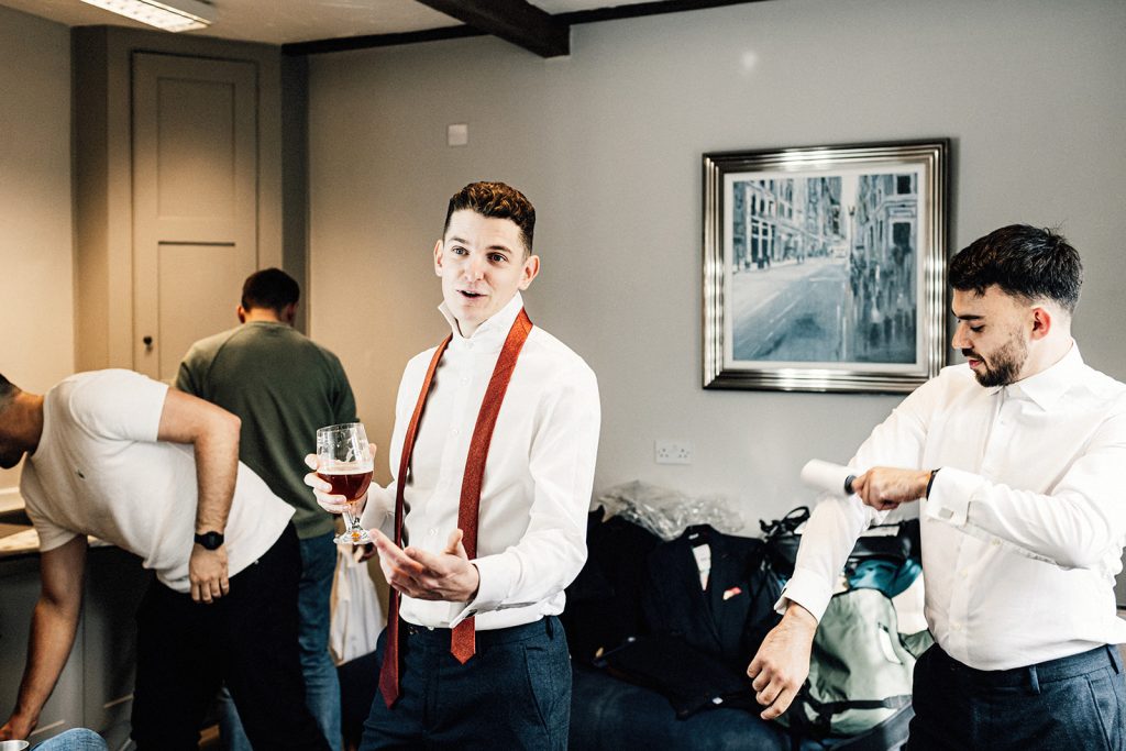 groomsmen getting ready while having a beer at Winters Barns wedding venue