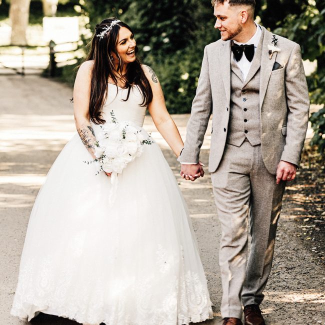 bride and groom holding hands walking at Chilham Village Hall