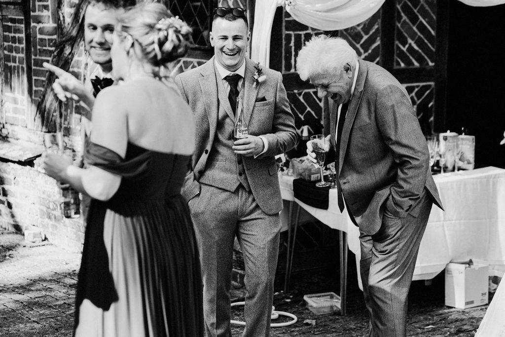 wedding guests standing outside laughing