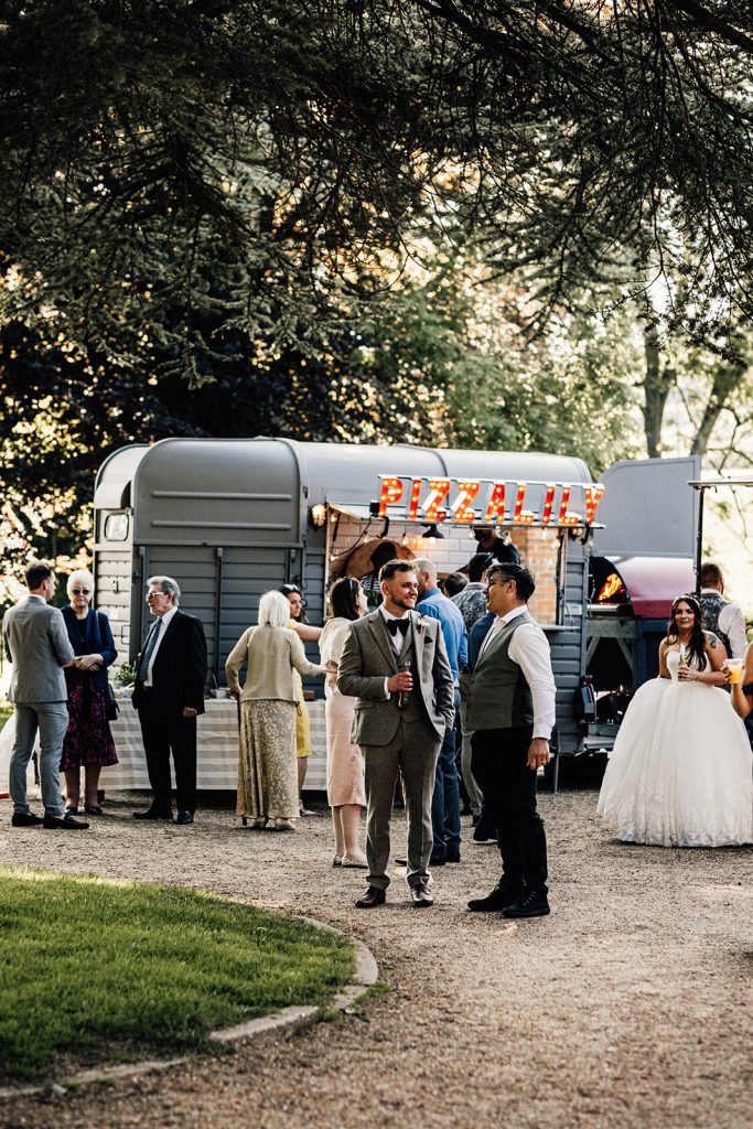 groom standing outside with guest at wedding reception