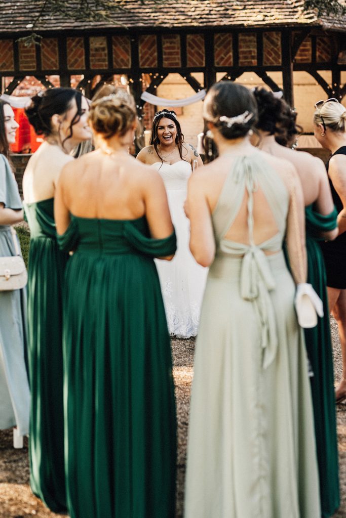 bride approaching her bridesmaids at wedding reception