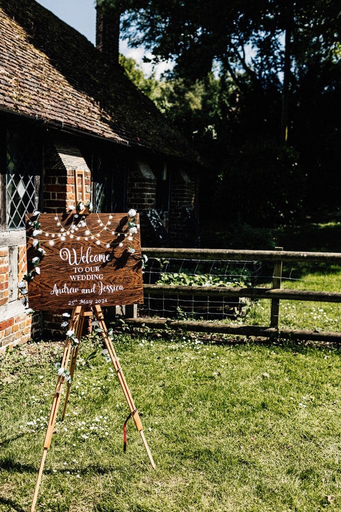 wooden wedding sign set up on easel taken by Chilham Village Hall wedding photographer