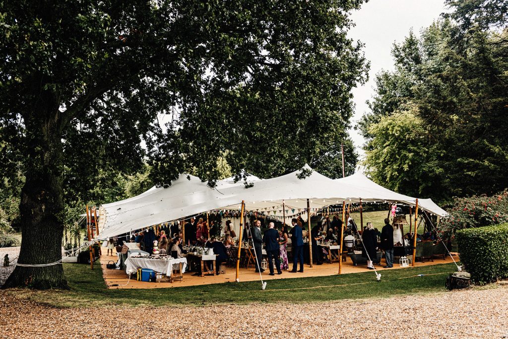 marquee with wedding guests at a wedding at Guston Court