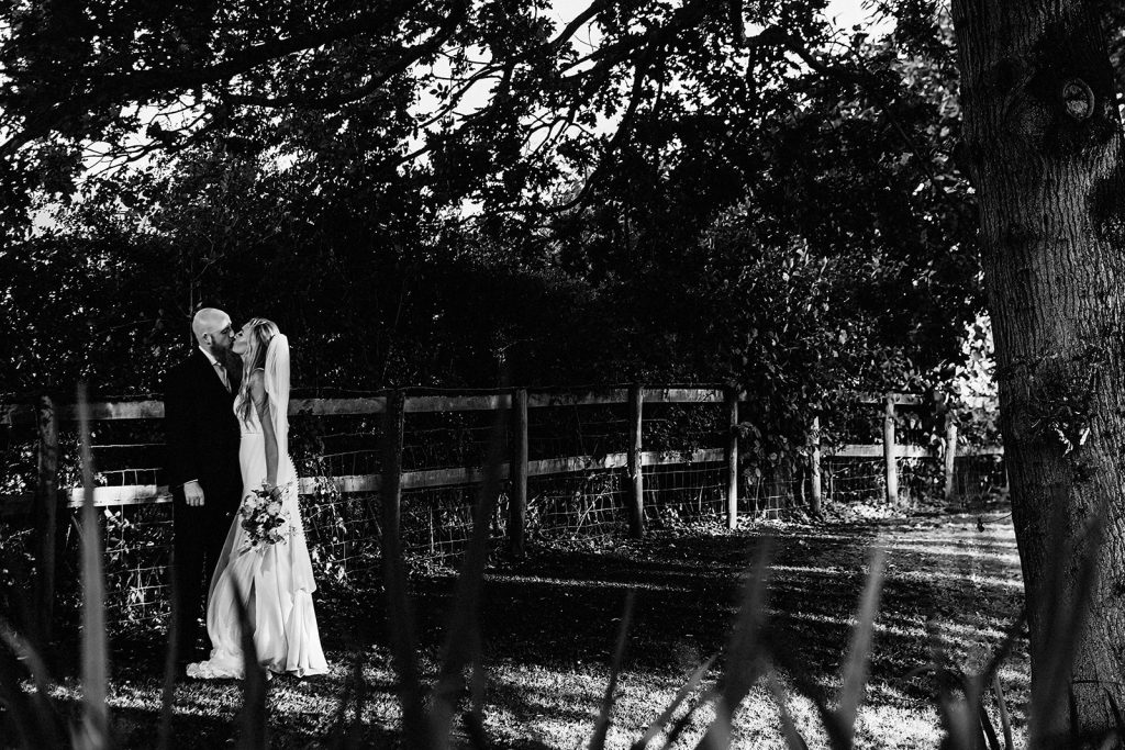 wedding portrait of bride and groom kissing in the grounds of Guston Court Wedding venue