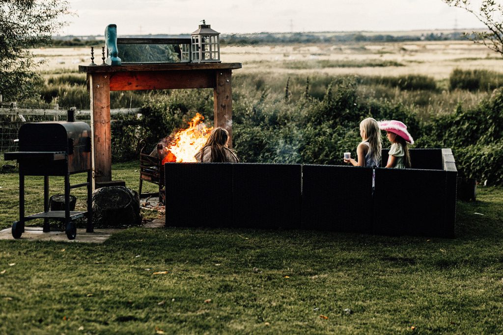 children at wedding in front of open fire sitting outside