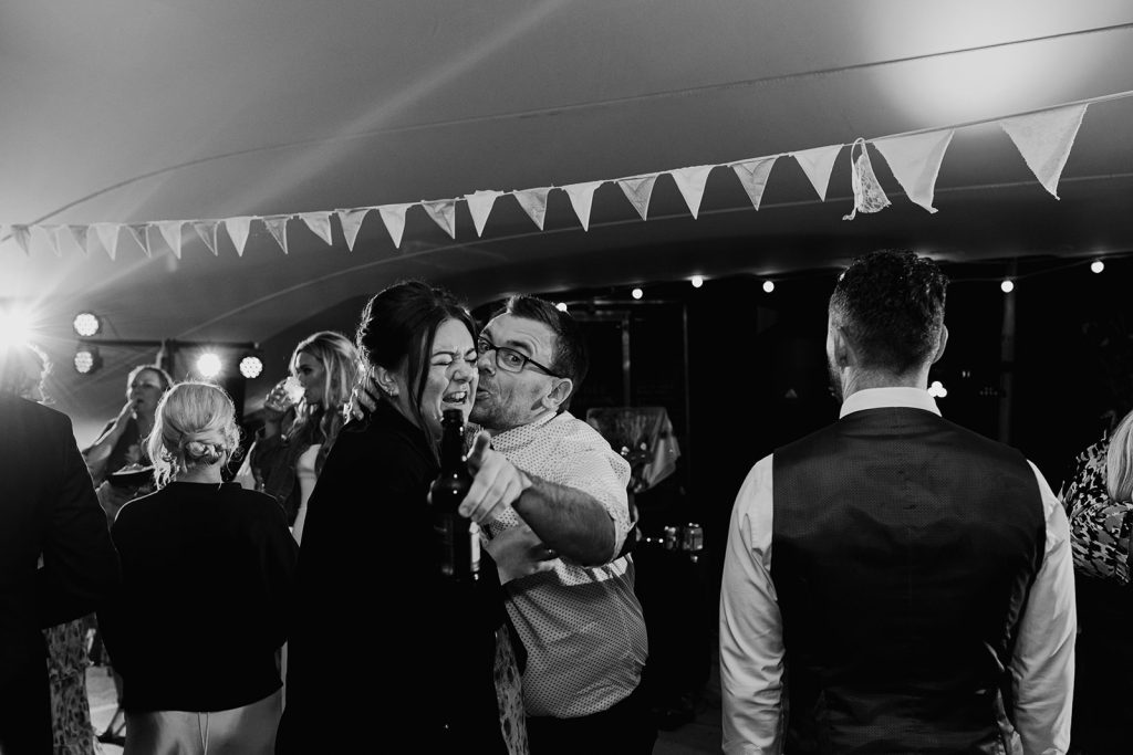 wedding guests on dance floor messing about and looking towards camera