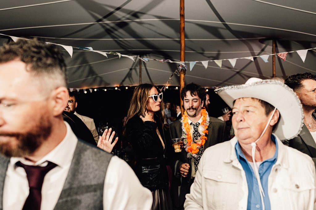 wedding guests standing and drinking in wedding marquee