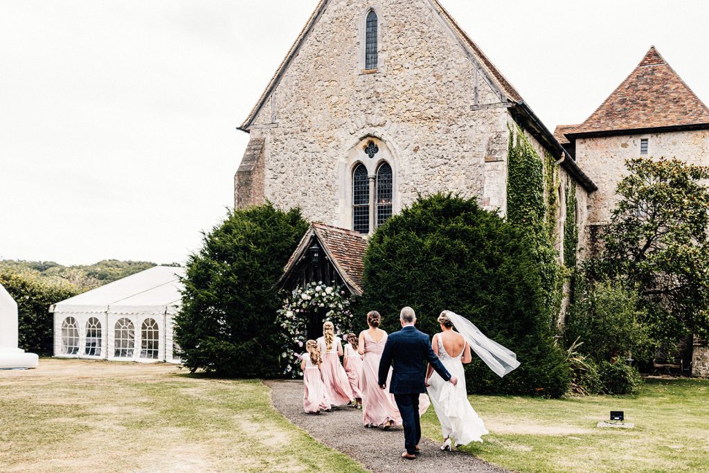 bridal party making their way to Bilsington Priory wedding