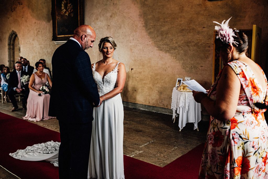 bride and groom holding hands during a wedding poem being read to them