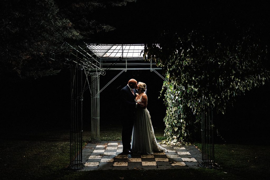 wedding portrait at night lit by flash in grounds of Bilsington Priory
