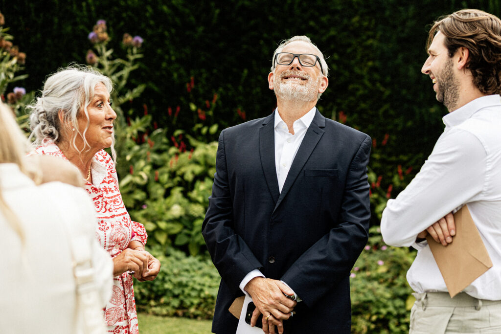 wedding guests chatting and laughing in the gardens of Swarling manor wedding venue.