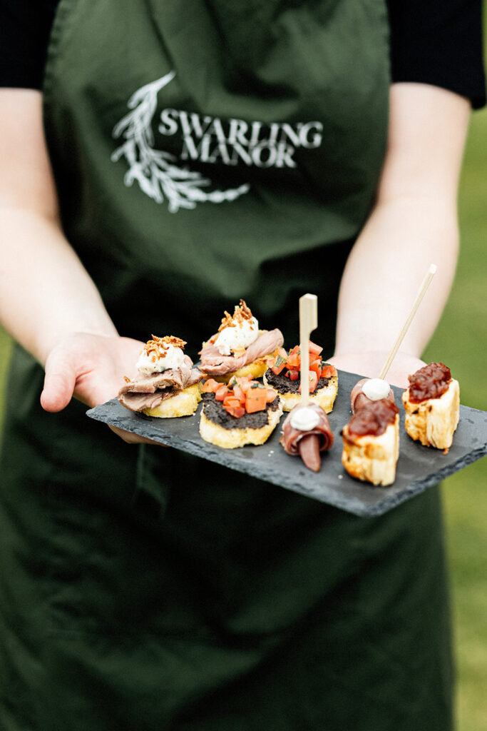 a member of the Swarling Manor staff holding a slate tray full of canapes at a Swarling Manor wedding.
