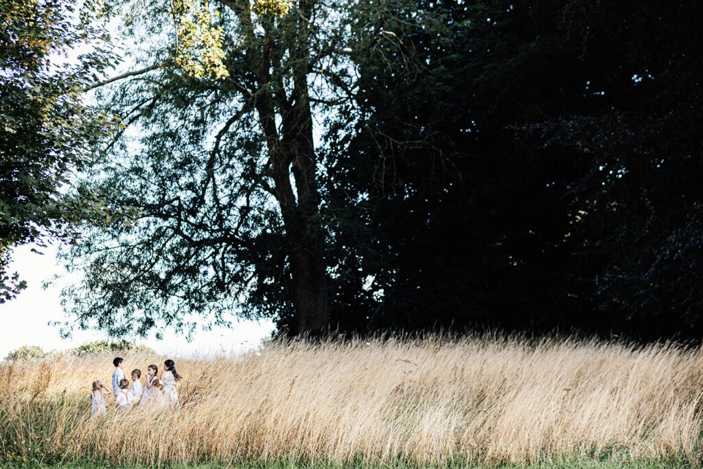 children playing in the long grass meadow at Swarling Manor wedding venue